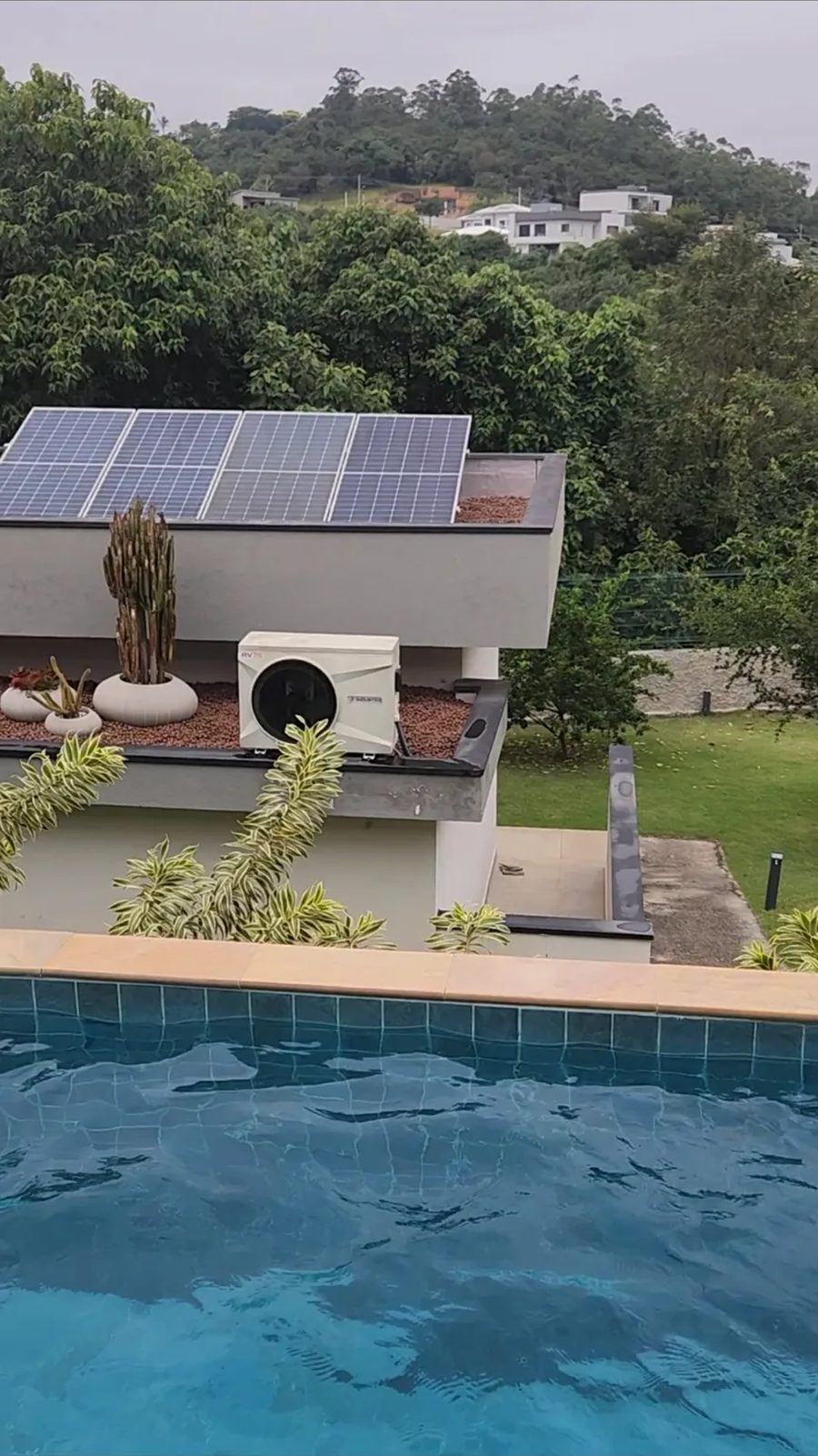Piscina de condomínio aquecida com bomba de calor Inverter e painéis fotovoltaicos ao fundo