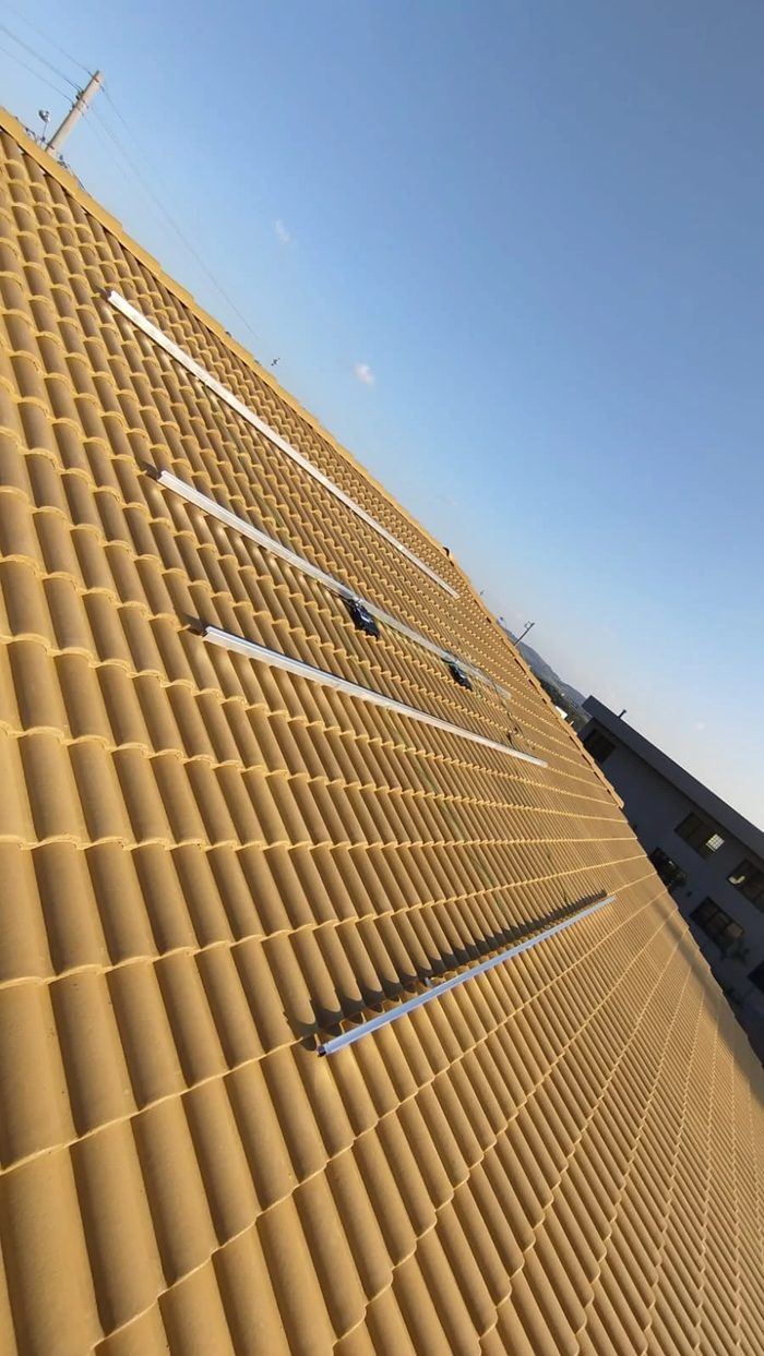 Estrutura de fixação e microinversores instalados em telhado de telha cerâmica