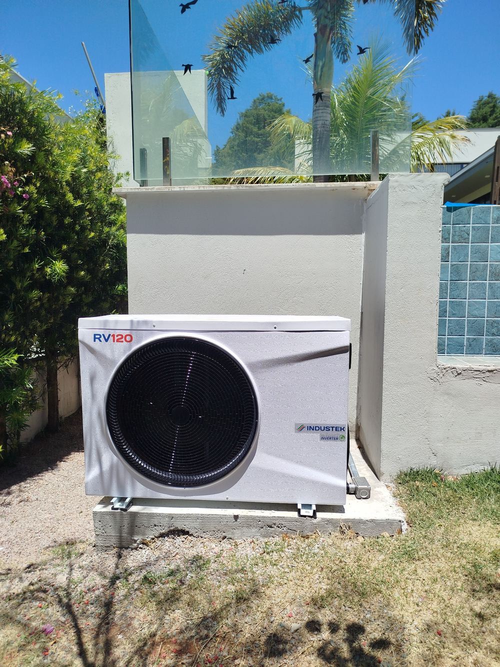 Bomba de calor Inverter RV120 instalada ao lado de piscina residencial